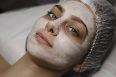 Lächelnde Frau mit Hautpflege-Gesichtsmaske im Schönheitssalon - ALKF00639