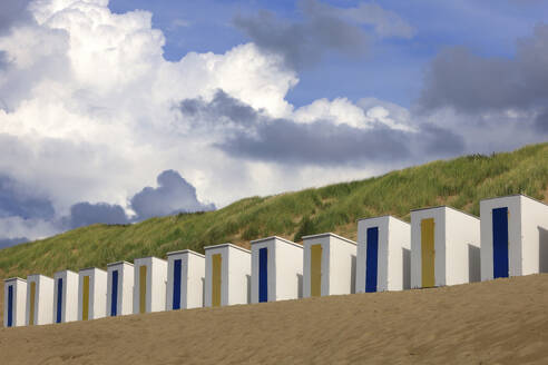 Reihe von Strandhütten mit grasbewachsener Düne im Hintergrund - JTF02373