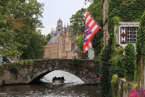 Belgium, West Flanders, Bruges, Boat sailing under old arch bridge - JTF02378