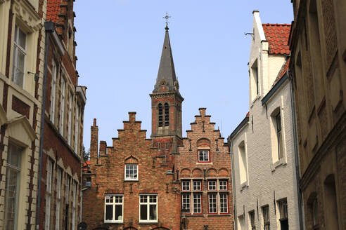 Belgium, West Flanders, Bruges, Historic houses with church bell tower behind - JTF02381