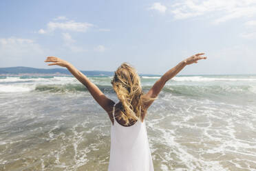 Woman standing with arms outstretched at beach - SIF00872