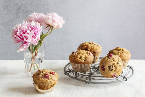 Studio shot of pink peonies and rhubarb muffins on cooling rack - EVGF04381
