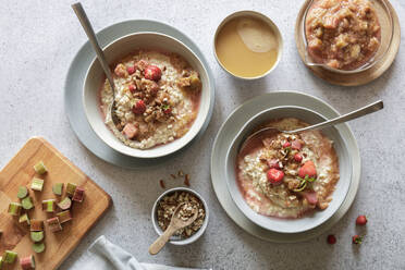 Studioaufnahme von zwei Schüsseln veganem Porridge mit Erdbeeren und Mandeln - EVGF04391