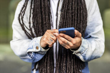 Man with long hair using smart phone - WPEF07669