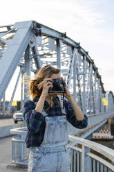 Frau fotografiert durch Kamera an Brücke - IKF01215