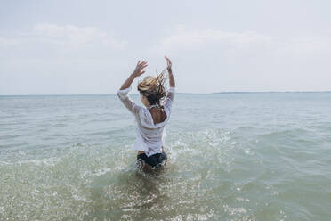 Woman with arms raised enjoying in sea - SIF00892