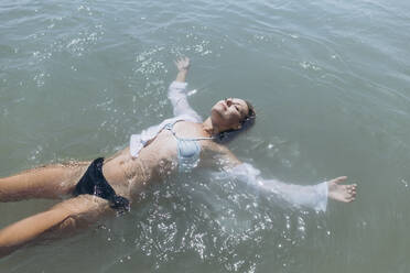 Woman floating on water in sea - SIF00897