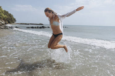 Happy woman jumping at beach - SIF00903