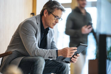 Älterer Geschäftsmann benutzt Tablet-PC im Büro - JSRF02578