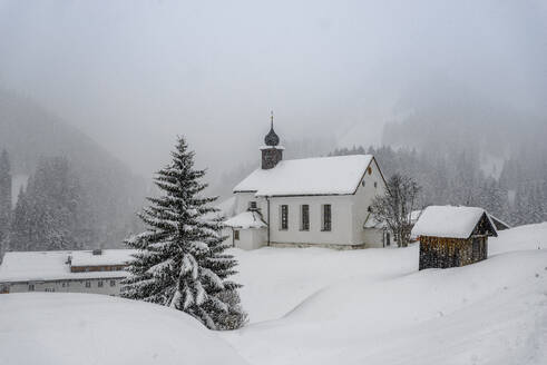 Österreich, Vorarlberg, Baad, Kirche in abgelegenem Bergdorf bei nebligem Wetter - EGBF00949