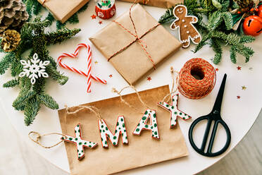 Top view Zusammensetzung der handgefertigten Weihnachtsgeschenk-Boxen auf dem Tisch mit verschiedenen Dekorationen und Schere platziert - ADSF46723