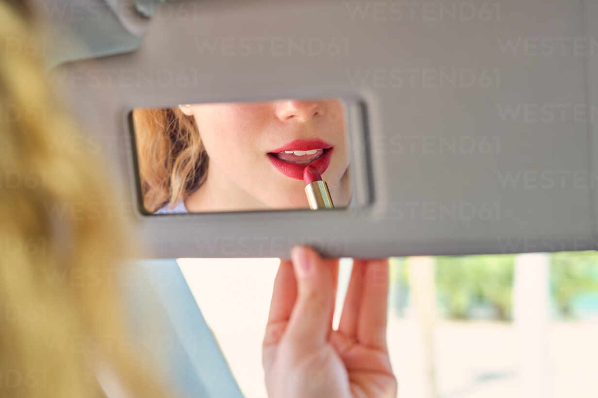 Crop weiblichen Fahrer Anwendung leuchtend roten Lippenstift und