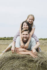 Happy family together on hay in field - EYAF02825