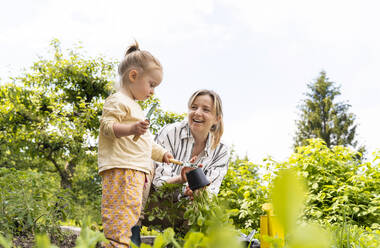 Glückliche Mutter und Tochter bei der Gartenarbeit im Gemüsegarten - NDEF01133
