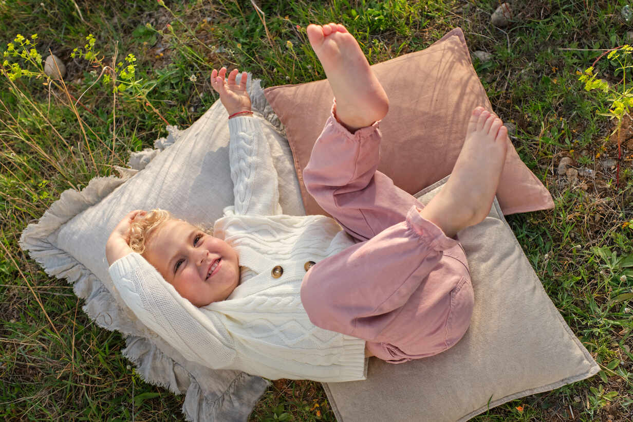 Crop faceless female wearing pink tights and denim shorts lying on lush  grassy meadow in summer countryside Stock Photo - Alamy