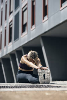Frau beim Sport auf dem Fußweg in der Nähe eines Gebäudes - JSRF02607