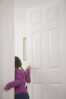 Rückansicht eines Mädchens beim Öffnen der Tür - FSIF06380