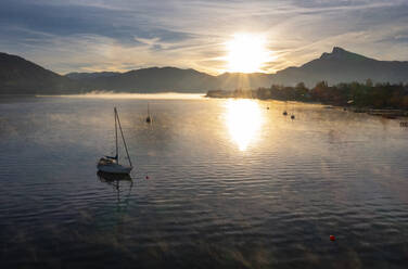 Österreich, Oberösterreich, Drohnenaufnahme von Segelbooten im Mondsee bei nebligem Sonnenaufgang - WWF06459