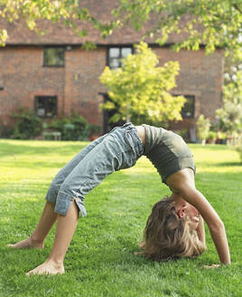 Mädchen Backbending im Garten - FSIF06402