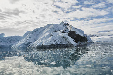 Schmelzender Eisberg auf sonniger blauer Meeresoberfläche vor der Antarktischen Halbinsel, Weddellmeer, Antarktis - FSIF06477