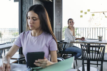 Two young women working at coworking space - ASGF04554