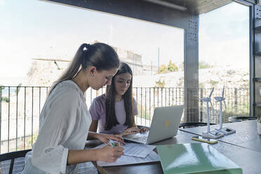 Two young female engineers working together at cafe table - ASGF04577