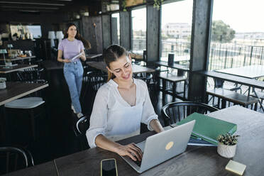 Zwei junge Frauen arbeiten gemeinsam an einem Projekt für nachhaltige Ressourcen im Coworking Space - ASGF04588