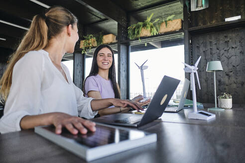 Junge Frauen testen Solarmodule bei der Arbeit im Coworking Space - ASGF04598