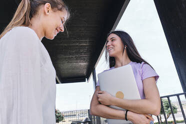 Two young women talking on balcony - ASGF04633