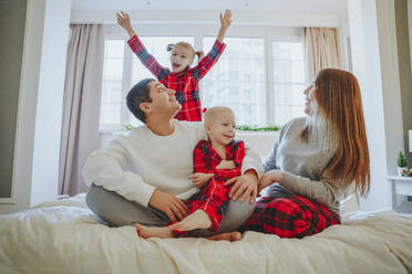 Glückliche Familie, die ihre Freizeit zu Hause im Bett verbringt - NLAF00129