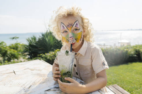 Girl with face painting drinking mojito in garden on sunny day - SIF00908