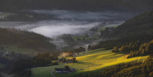 Austria, Salzburger Land, Ebenau, Panoramic view of foggy valley in Salzkammergut mountains at dawn - WWF06474