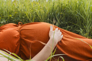 Schwangere Frau im Gras liegend - NDEF01169