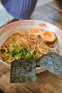 Closeup hohen Winkel der appetitlichen Keramikschale mit Ramen-Suppe und hölzerne Essstäbchen auf dem Tisch serviert - ADSF47057