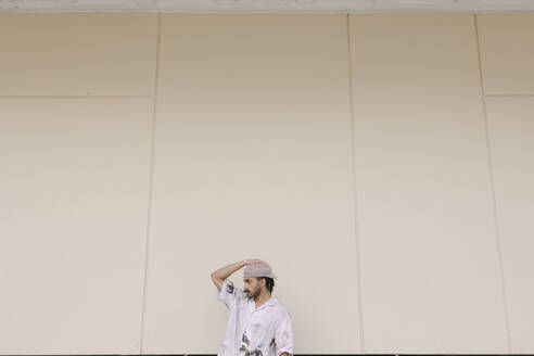 Thoughtful young man wearing beret cap in front of wall - DSIF00721