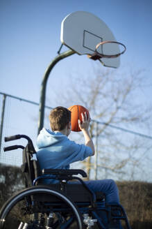 Teenage Boy In Wheelchair Playing Basketball Shooting Hoop - INGF12092