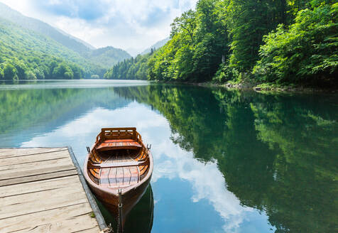 Wooden boat at pier on mountain lake. Biograd lake, Montenegro - INGF12106