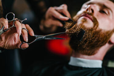 Barbershop, young man having a beard trimming - INGF12124