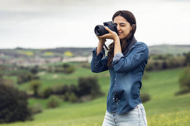 Lächelnde Frau, die durch die Kamera fotografiert - JSRF02616