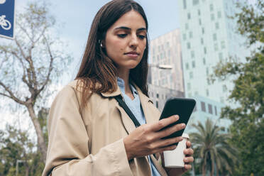 Junge Frau benutzt Smartphone in der Stadt - JSRF02621