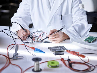 Hands of scientist working on circuit board in laboratory - CVF02488