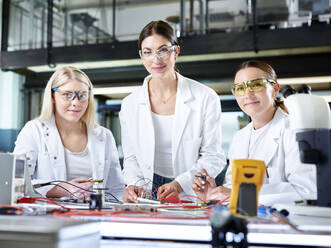 Smiling engineers with electronic work tools in laboratory - CVF02498