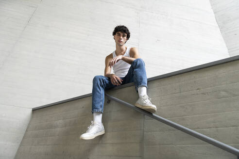 Young man sitting on wall - LMCF00549
