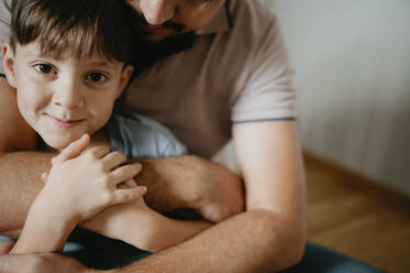 Father hugging son at home - ANAF02139