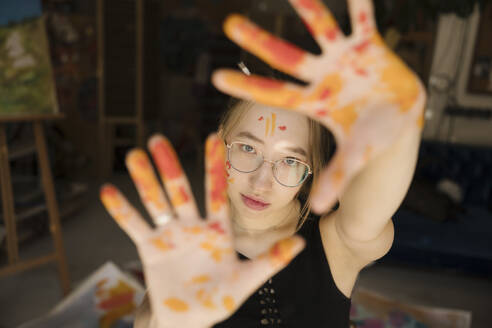 Young painter showing palm of hands at workshop - YBF00253