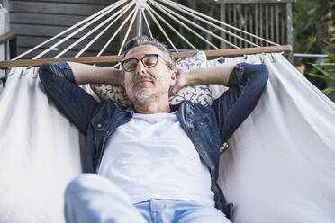 Mature man napping in hammock - UUF30274