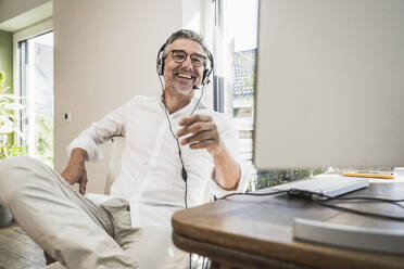 Älterer Vertriebsmitarbeiter im Gespräch über Headset im Home Office - UUF30304