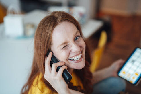 Happy woman talking on phone at home - KNSF09873