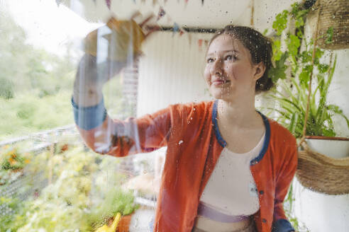 Teenage girl cleaning balcony door - IHF01735