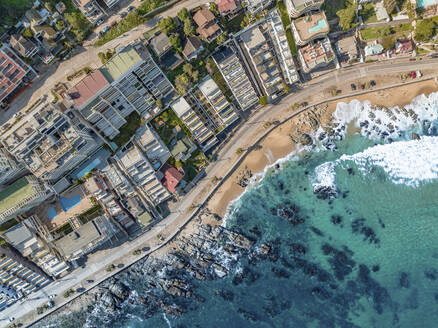 Aerial Top Down View Of Modern Luxury Seaside Apartment Buildings And Coastal Road At Playa Cochoa Beach In Vina Del Mar, Valparaiso, Chile. - AAEF21898